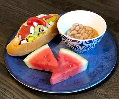 Plate with hotdog beans and watermelon