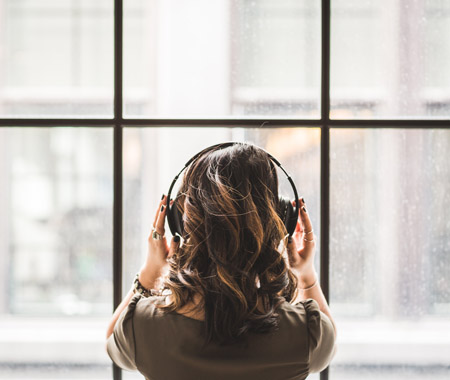 Crush your creative rut with sound. Image of women with headphones.