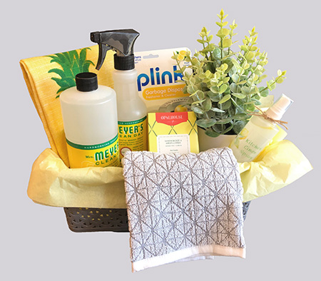 a housewarming fit basket full of cleaning supplies, plant and dish towel