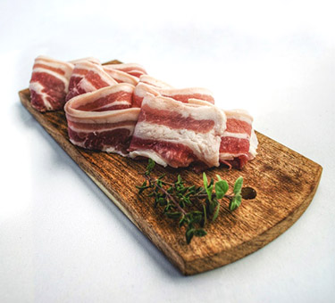 slices of bacon on a wood board Christmas breakfast strata ingredient 