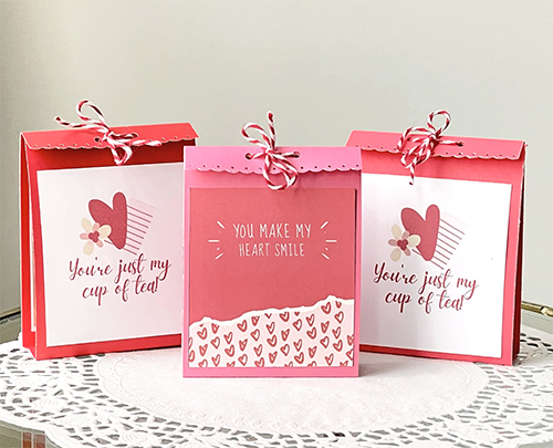 Three DIY Mini Gift Bags sitting on a paper doily
