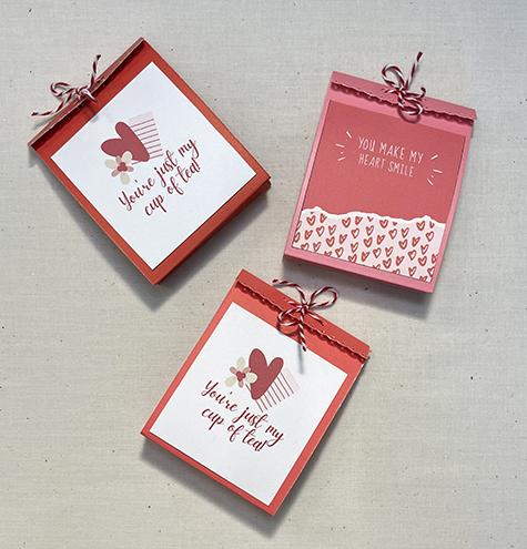 three mini paper gift bags with string closures